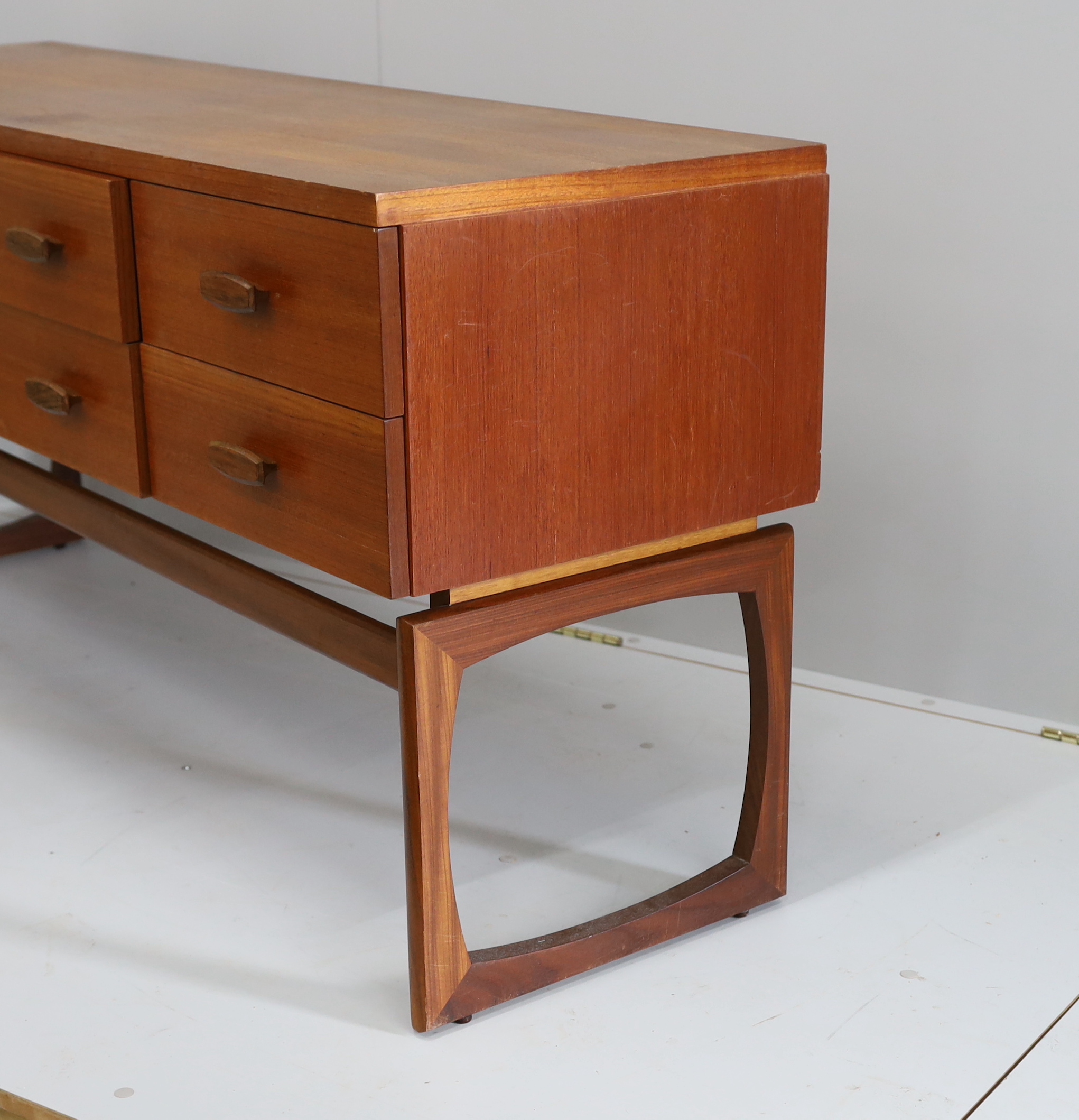 Ib Kofod Larsen for G Plan, a teak six drawer dressing table, length 152cm, depth 46cm, height 71cm (mirror back present but in need of repair)